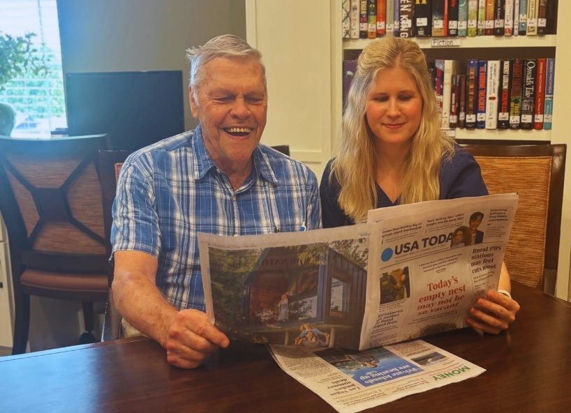 Florence and resident read newspaper together.