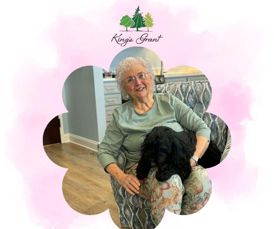 Resident at King’s Grant senior living community sitting with her dog