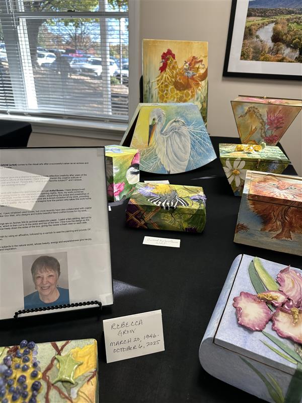 A memorial art display featuring hand-painted boxes and artwork by resident Rebecca Grim.